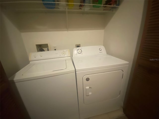 clothes washing area with independent washer and dryer and laundry area