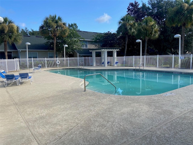 pool featuring a pergola, fence, and a patio area