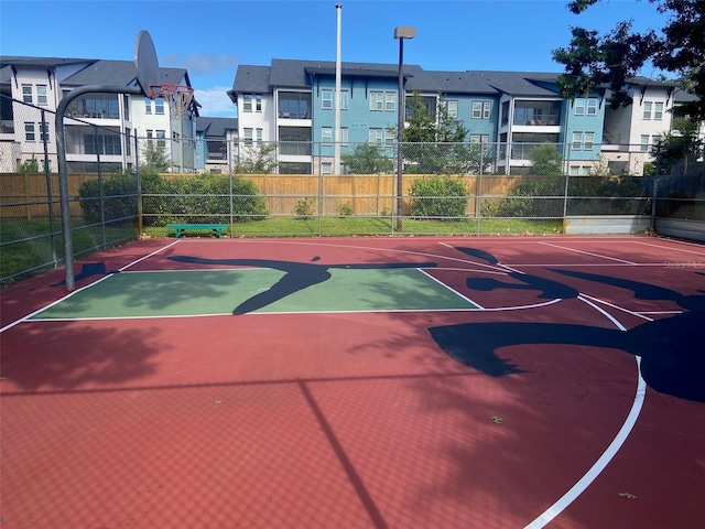 view of basketball court featuring a residential view, community basketball court, and fence