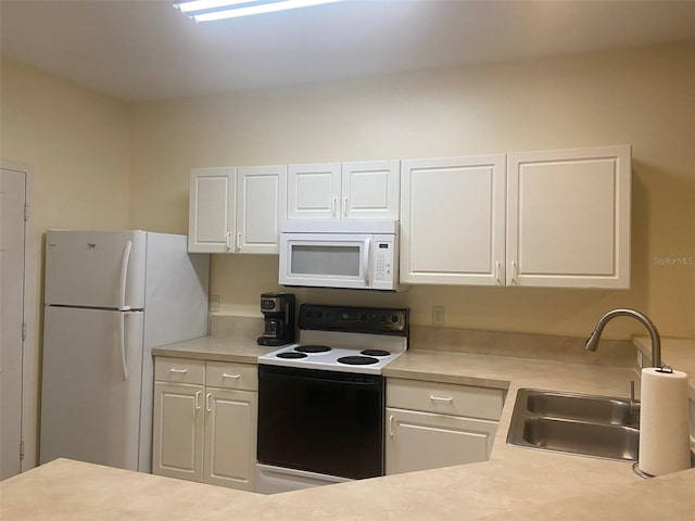 kitchen featuring sink, white cabinets, and white appliances