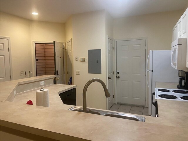 interior space with electric panel, light countertops, a sink, white cabinetry, and white microwave