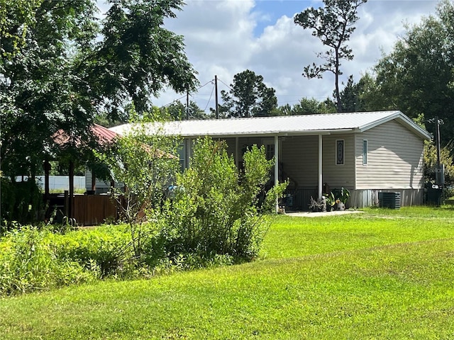 exterior space with cooling unit and a yard