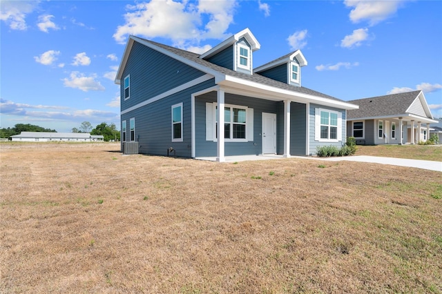 view of front of house featuring central air condition unit and a front yard