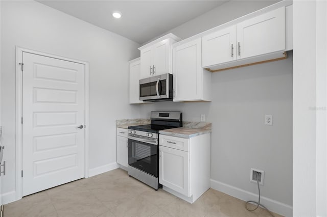 kitchen featuring light tile patterned flooring, white cabinetry, and stainless steel appliances