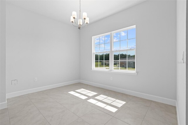 tiled empty room with a chandelier