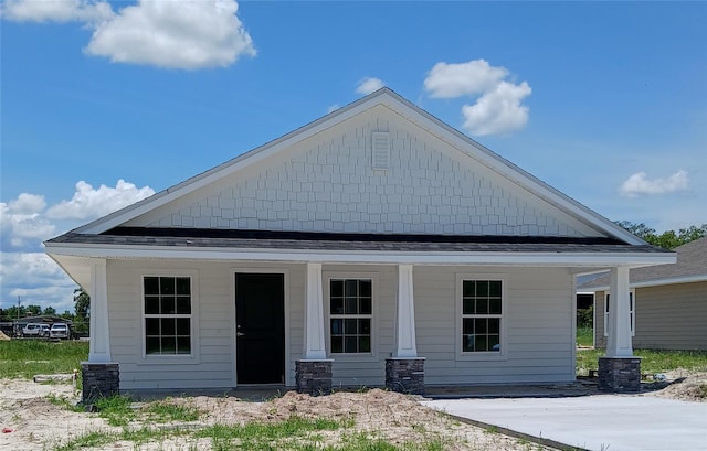 rear view of house featuring covered porch