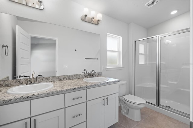 bathroom with tile patterned flooring, vanity, toilet, and a shower with door