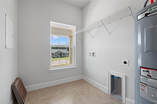 clothes washing area with hookup for an electric dryer, light tile patterned floors, washer hookup, and water heater