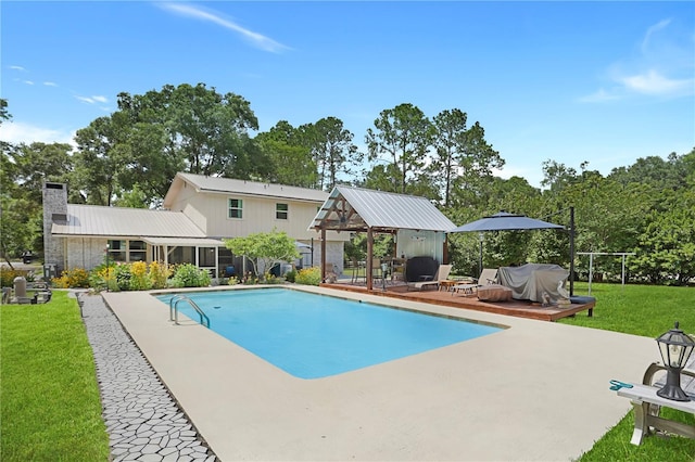 view of swimming pool featuring a lawn, area for grilling, and a patio area