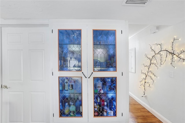 interior details with hardwood / wood-style flooring and ornamental molding