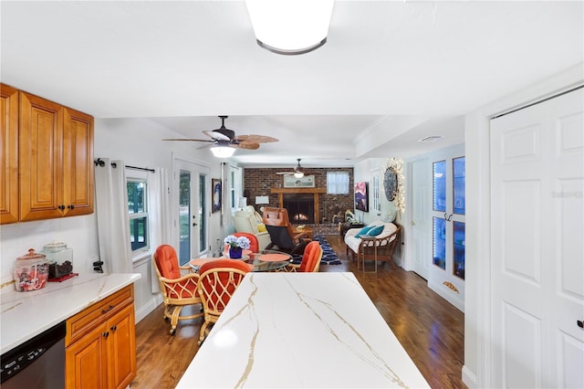 dining room with ceiling fan, a fireplace, crown molding, and dark hardwood / wood-style floors