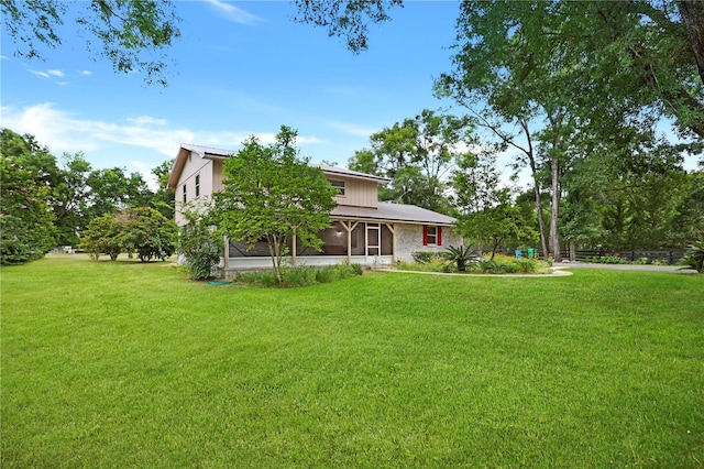 view of front of property with a sunroom and a front yard