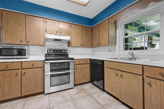 kitchen featuring stainless steel appliances, sink, light tile patterned floors, and decorative backsplash