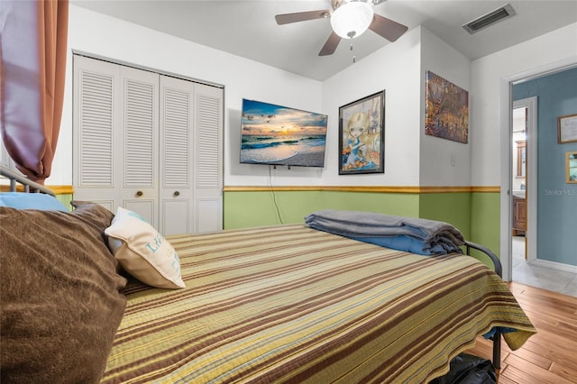 bedroom with ceiling fan, hardwood / wood-style floors, and a closet