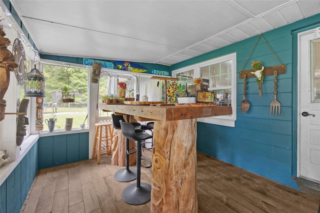 bar with dark wood-type flooring, wooden counters, and blue cabinets