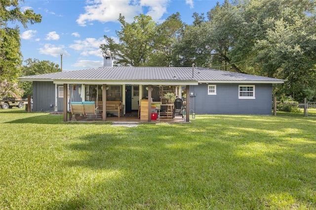 back of house with an outdoor living space and a yard