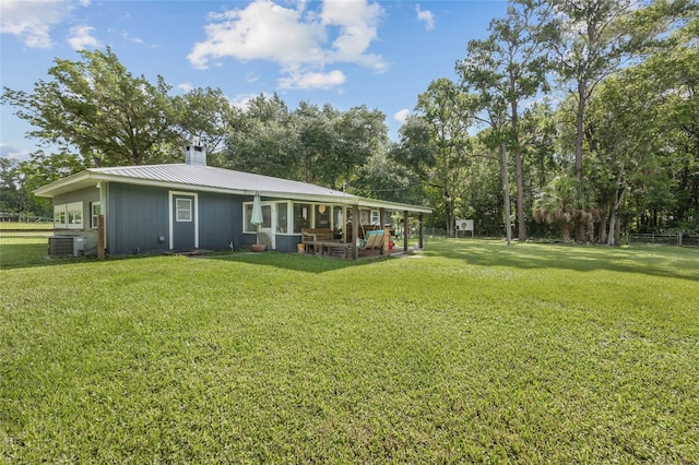 back of house with a lawn and central air condition unit