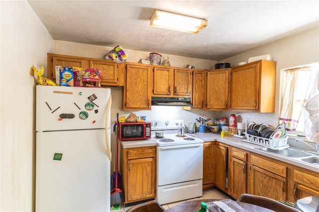 kitchen with light tile patterned floors, white appliances, and sink