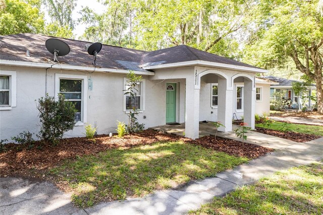 ranch-style house featuring covered porch and a front yard