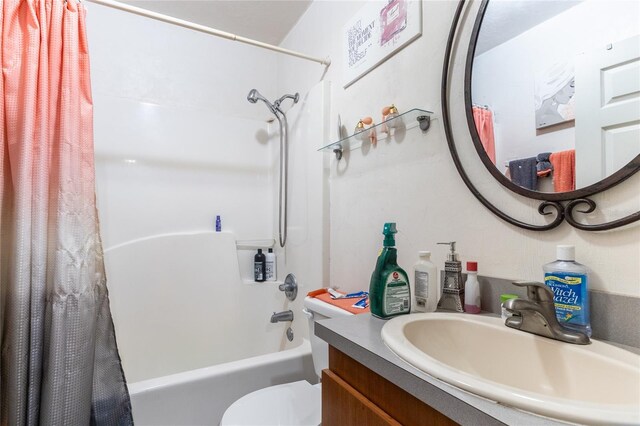 full bathroom with vanity, shower / bath combination with curtain, and toilet