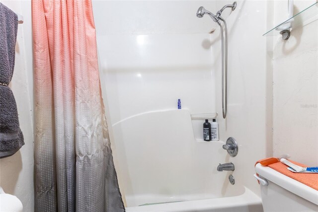 bathroom featuring shower / tub combo and toilet