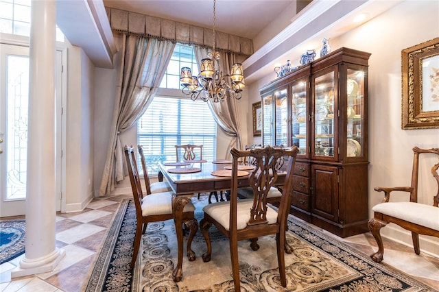 dining space featuring a chandelier and ornate columns