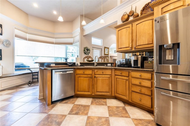 kitchen featuring kitchen peninsula, stainless steel appliances, sink, a high ceiling, and hanging light fixtures