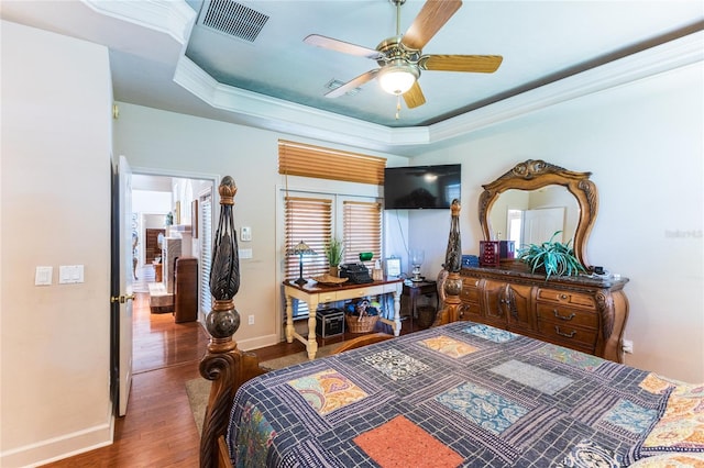 bedroom with a raised ceiling, ceiling fan, ornamental molding, and hardwood / wood-style flooring