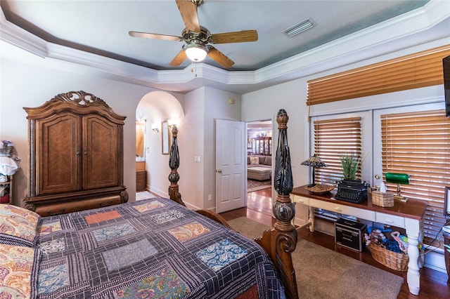 bedroom featuring ceiling fan, ornamental molding, and a tray ceiling