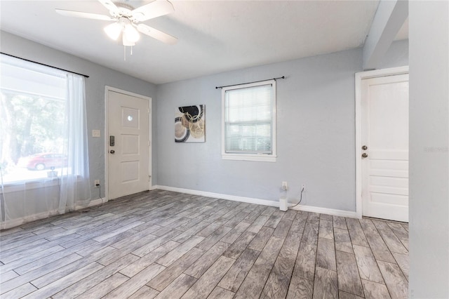 foyer with light wood-style floors, ceiling fan, and baseboards