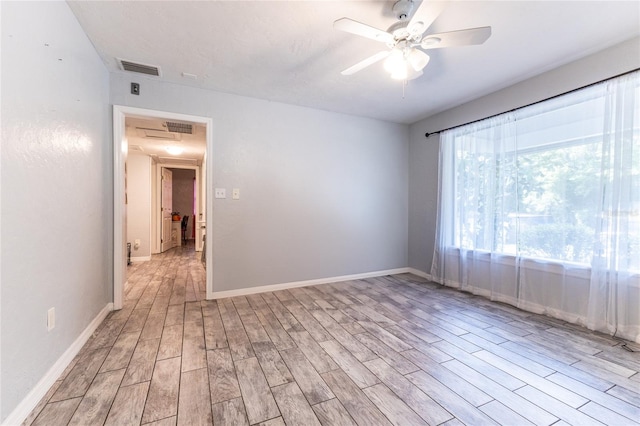 unfurnished room featuring baseboards, visible vents, ceiling fan, and light wood finished floors