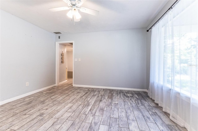 unfurnished room featuring ceiling fan, baseboards, and light wood-style floors