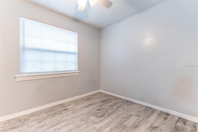 empty room featuring a ceiling fan, baseboards, and wood finished floors