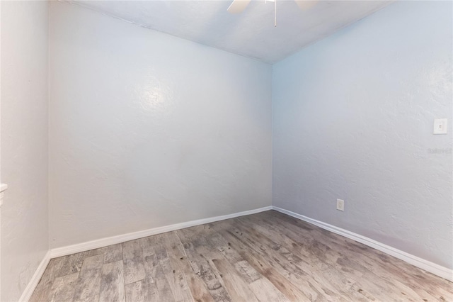 unfurnished room with a ceiling fan, baseboards, and wood finished floors