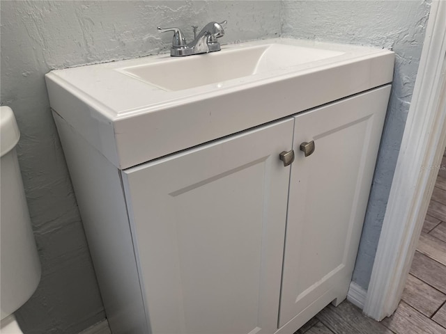 bathroom with a textured wall and vanity