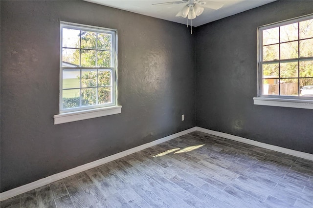 spare room featuring a ceiling fan, baseboards, and wood finished floors