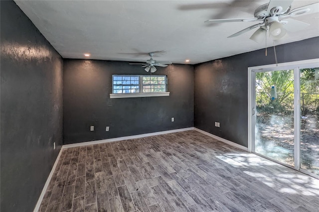 spare room with a ceiling fan, baseboards, and wood finished floors