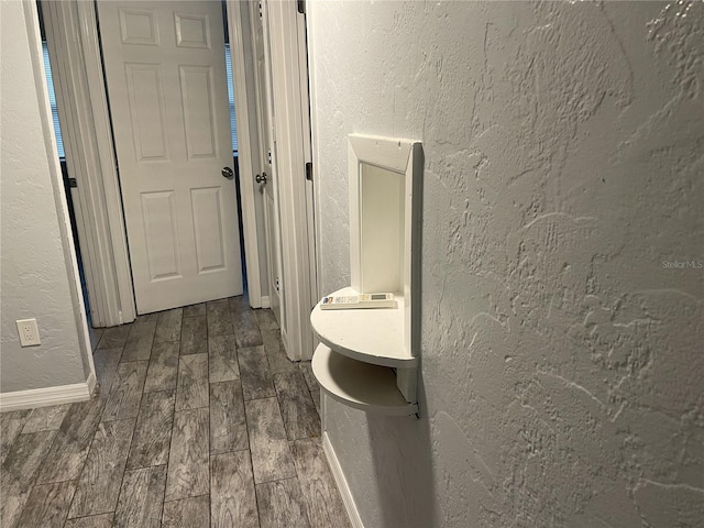 bathroom with a textured wall and wood tiled floor