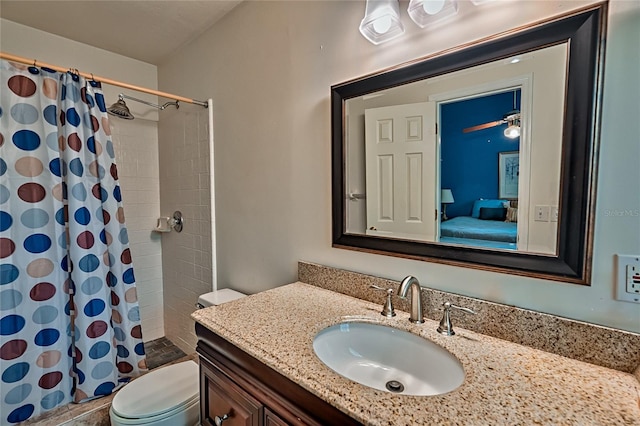 bathroom featuring vanity, toilet, walk in shower, and ceiling fan