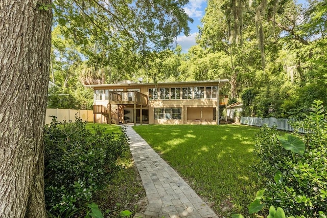 back of house featuring a wooden deck and a yard