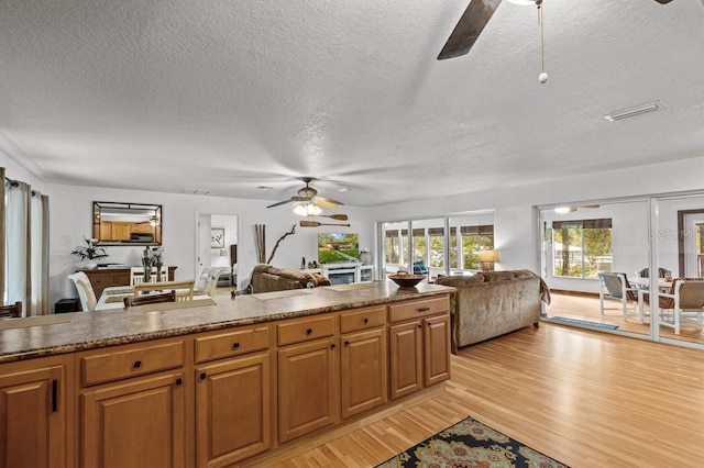 kitchen featuring ceiling fan, light hardwood / wood-style flooring, and a textured ceiling