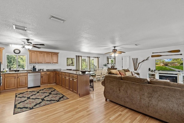 kitchen featuring kitchen peninsula, a wealth of natural light, dishwasher, and light hardwood / wood-style flooring