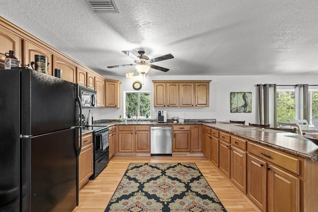 kitchen with ceiling fan, light wood-type flooring, black appliances, a textured ceiling, and sink