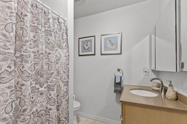 bathroom featuring tile flooring, toilet, a textured ceiling, and large vanity