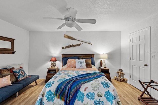 bedroom featuring a textured ceiling, ceiling fan, and light hardwood / wood-style flooring