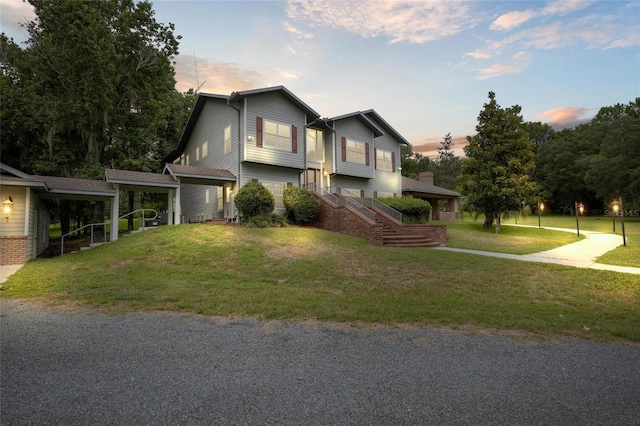 view of front of house with a yard and a carport