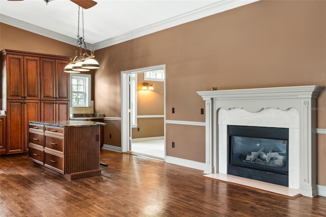 kitchen with dark hardwood / wood-style flooring, decorative light fixtures, and crown molding