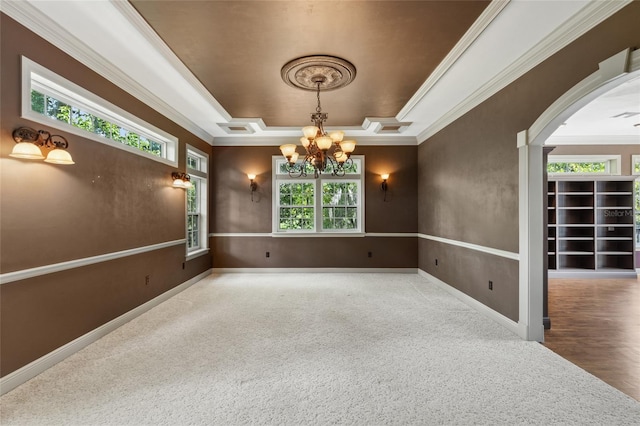 unfurnished room featuring an inviting chandelier, carpet flooring, ornamental molding, and a tray ceiling