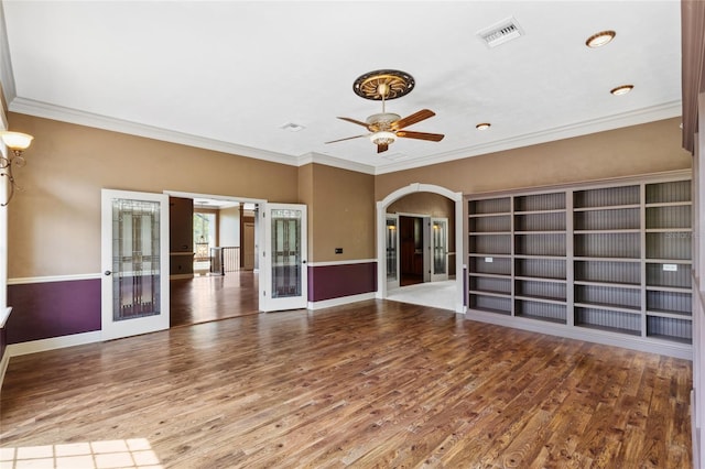 unfurnished living room featuring crown molding, hardwood / wood-style floors, and french doors