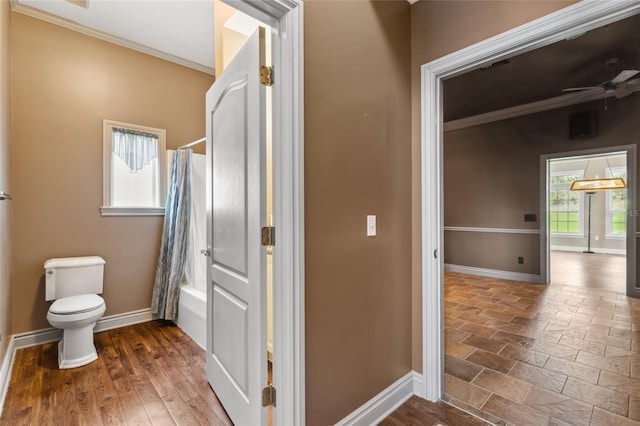 bathroom featuring hardwood / wood-style floors, shower / tub combo, ceiling fan, toilet, and crown molding